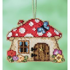 a cross stitch ornament with a dog house on it's front and side