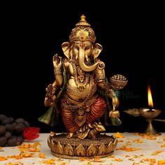 an elephant statue sitting on top of a table next to a candle and some flowers