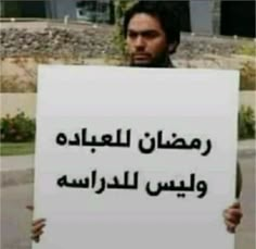 a man holding up a sign in arabic