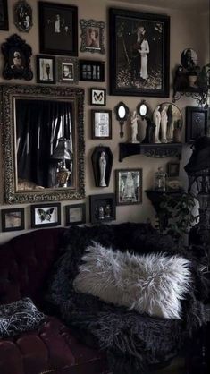 a living room filled with furniture and pictures on the wall next to a potted plant