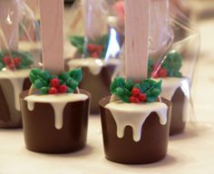 chocolate covered candies with white icing and holly decorations on them are sitting on a table