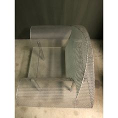 a chair made out of mesh sitting on the floor next to another chair that is empty