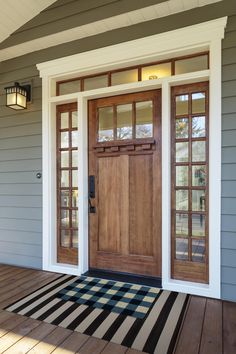 the front door of a house with two sidelights on it and wood flooring