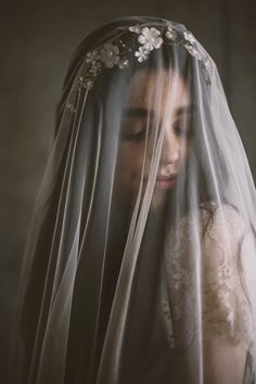 a woman wearing a veil with flowers on it