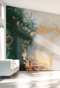 a white couch sitting in front of a green and gold painting on the wall next to a window