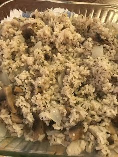 a glass dish filled with rice and mushrooms