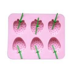 strawberry shaped ice tray with green straws in it