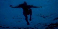 a woman is swimming in the water with her arms spread out and she has long hair