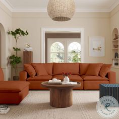 a living room filled with furniture and a large round coffee table in front of a window