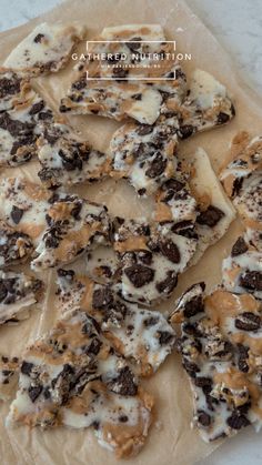 chocolate chip cookies and marshmallows are arranged on top of parchmented paper