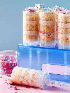 three plastic containers filled with cake and sprinkles on top of a table