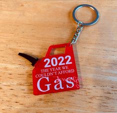 a keychain that has been placed on top of a wooden table with the year we couldn't afford gas