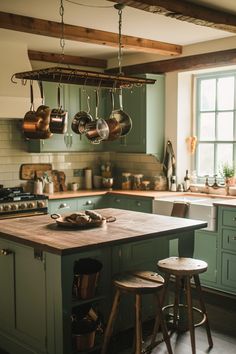 a kitchen with green cabinets and wooden stools next to an island in the middle