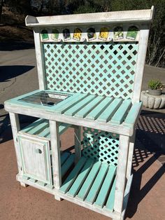 an outdoor kitchen made out of wood and painted blue with white lattice design on the top