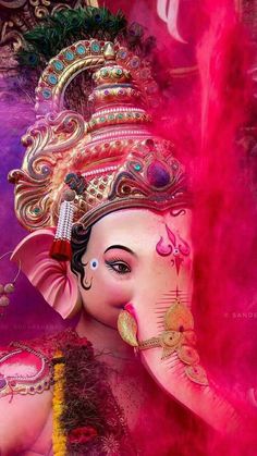 an elephant is painted in pink and gold with feathers on it's head,