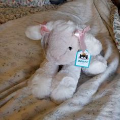 a white teddy bear sitting on top of a bed