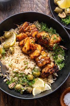 a bowl filled with rice and chicken on top of a wooden table