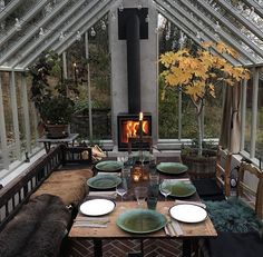 a dining room table with plates and place settings in front of an open fire place