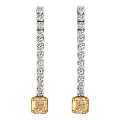 Stunning dangling diamond earring, each center stone GIA certified with “fancy yellow look” 5.20ct total diamond weight.  Two matching center cushion diamonds 3.00 carats total. One stone YX color grade and ther other WX color grade. One stone VS1 clarity grade and the other SI1 clarity grade. Complimented by 22 round brilliant diamonds, 2.20ct. Approximately G/H color and SI clarity. 18k white & yellow gold. Accommodated with an up-to-date digital appraisal by a GIA G.G. once purchased, upon request. Please contact us with any questions.  GIA Report Number 2183599396 6187702838 Diamond Dangle Earrings, Cushion Diamond, Diamond Earring, Diamond Drop Earrings, Yellow Diamond, Round Brilliant, Beverly Hills, Yellow White, Diamond Earrings