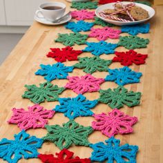 crocheted table runner on wooden table with plate of cookies and cup of coffee