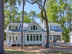 a white house surrounded by trees and grass