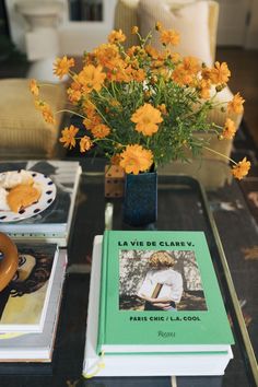 a table topped with yellow flowers and books