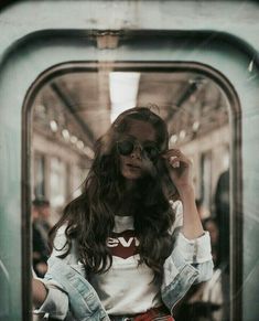 a woman is talking on her cell phone while riding the subway