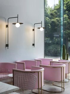 the interior of a restaurant with pink chairs and tables in front of large glass windows