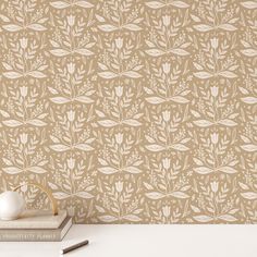 the wallpaper is beige and has white flowers on it, along with two books