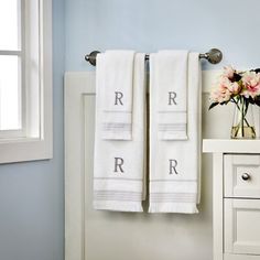 two white towels are hanging on a towel rack