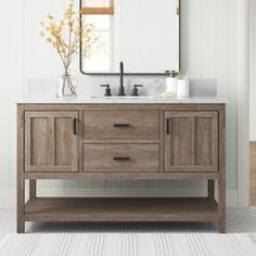 a bathroom vanity with two sinks and a large mirror above it, along with a rug on the floor