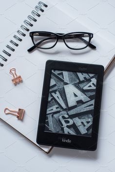 an open book with glasses on top of it next to a pair of eyeglasses