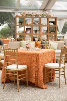 an orange table cloth is on top of the chairs