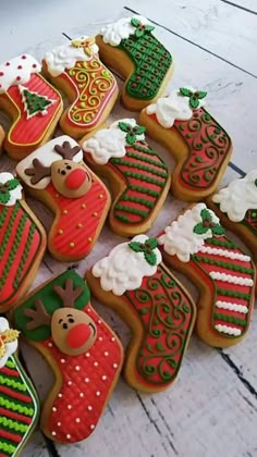 decorated christmas cookies arranged in rows on a table top with white wood boards behind them