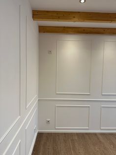 an empty room with white walls and wood flooring on the wall is shown in this image