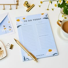 a notepad sitting on top of a desk next to a cup of coffee