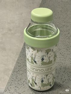 a green and white cup sitting on top of a counter