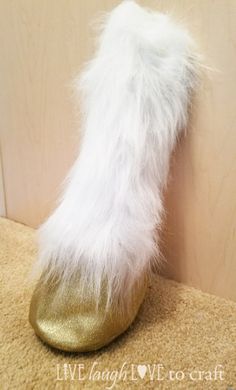 a pair of gold and white furry boots sitting on top of a carpeted floor