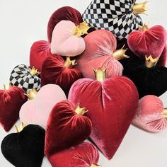 several heart shaped cushions with gold crowns on them are arranged in the shape of hearts