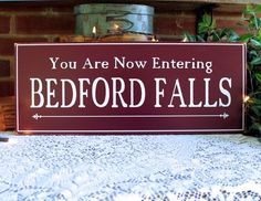 there is a sign that says you are now entering bedford falls on the table