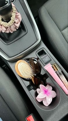 the interior of a car with various items in it and a pink flower on the center console