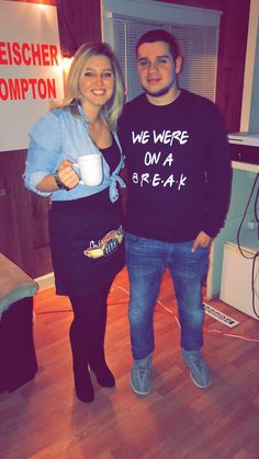 a man and woman standing next to each other holding coffee cups in front of a sign that says we were on a break