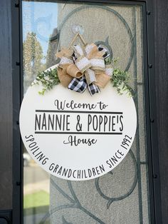 a welcome sign hanging on the front door to nannie & poppies house in grandchild