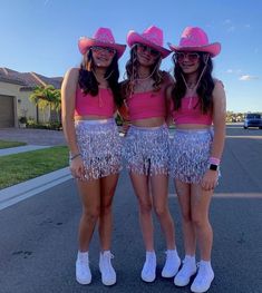 three girls wearing pink hats and fringe skirts