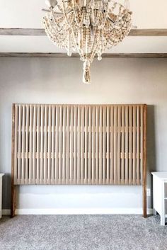 a chandelier hanging from the ceiling above a bed in a room with carpeted flooring