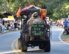 a man driving down the street in a cart with an advertisement on it that says roll the dice if you dare