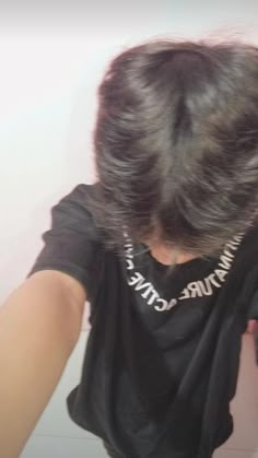 the back of a woman's head wearing a black shirt with white writing on it