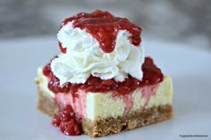 a piece of cheesecake with whipped cream and strawberries on top