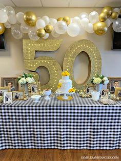 a table topped with a cake and balloons next to a 50th birthday party sign that says 50