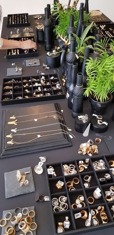 a table topped with lots of different types of rings and bracelets on trays